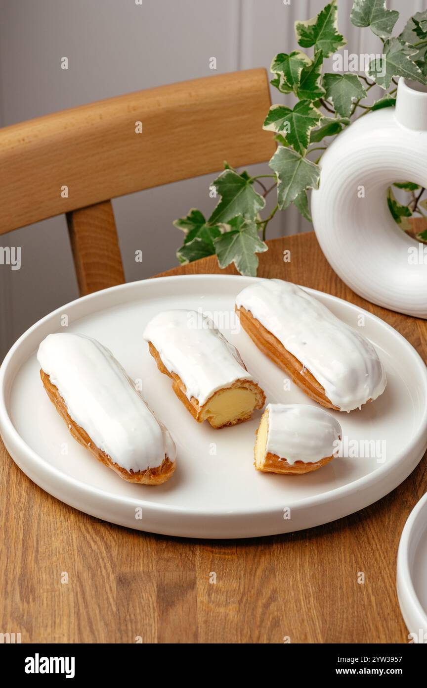 eclairs with white vanilla cream on a plate Stock Photo