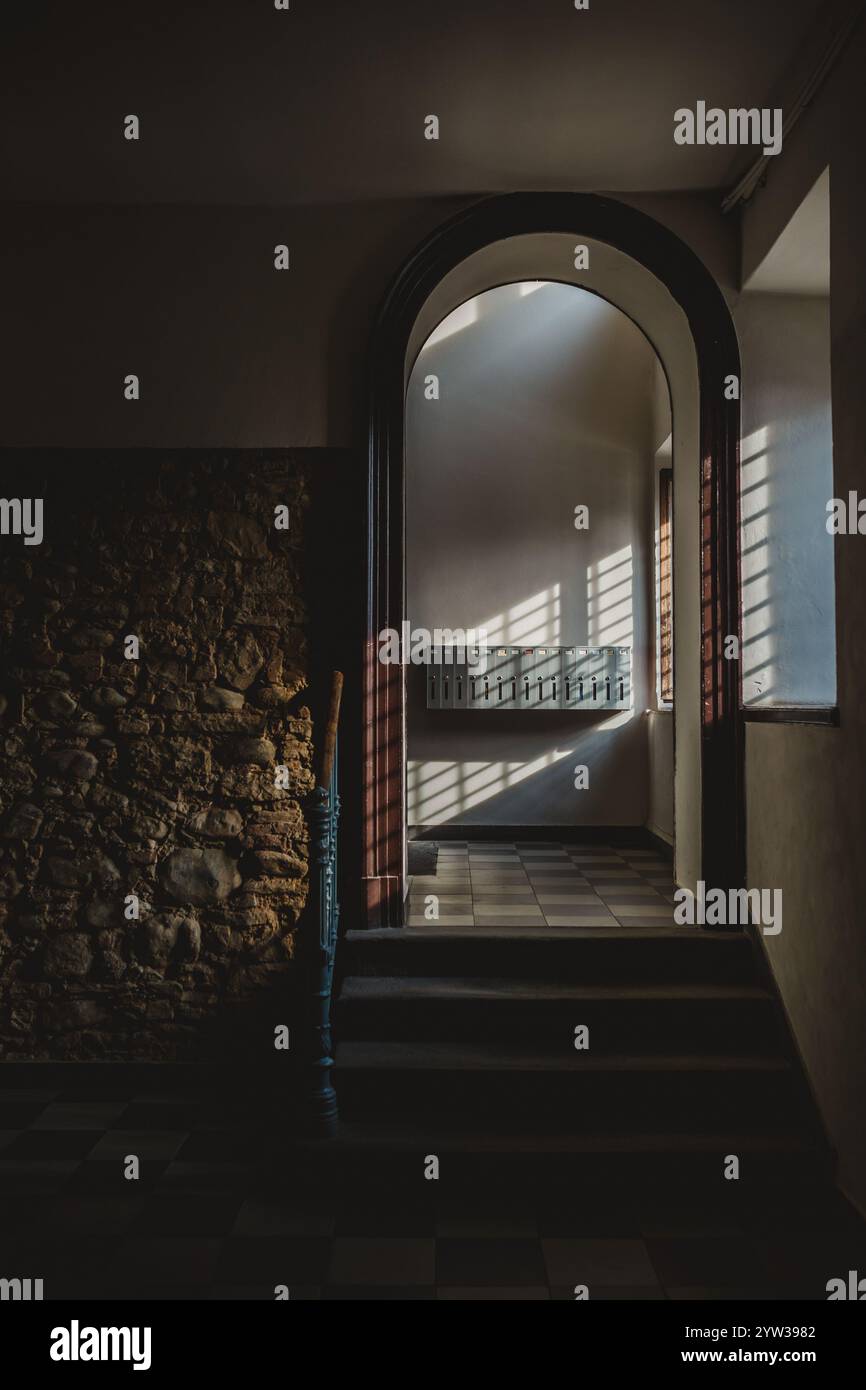 An arched doorway with slanting sunlight Stock Photo