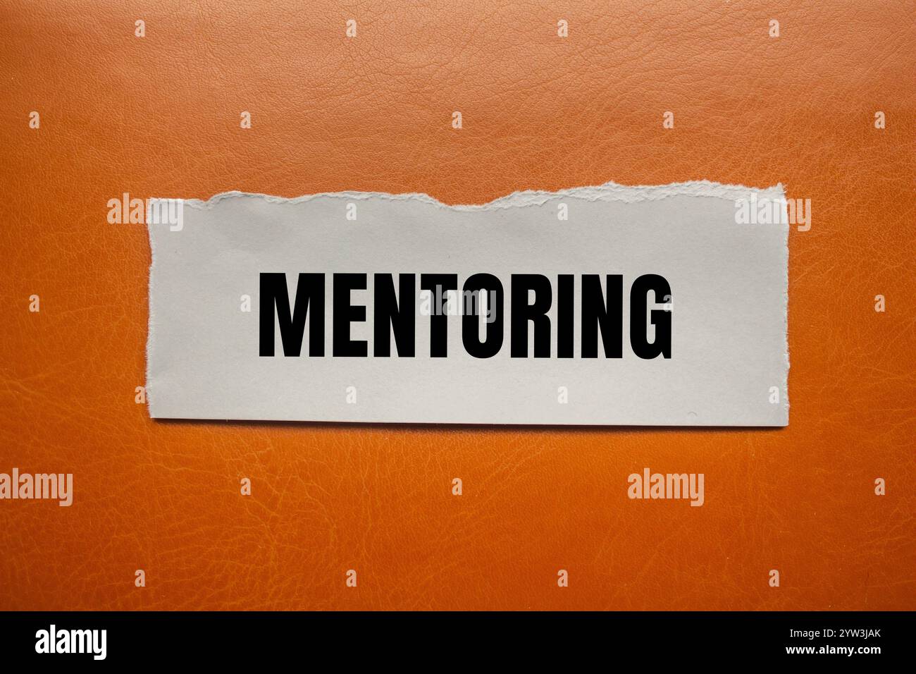 Mentoring message written on ripped torn paper piece with brown ...