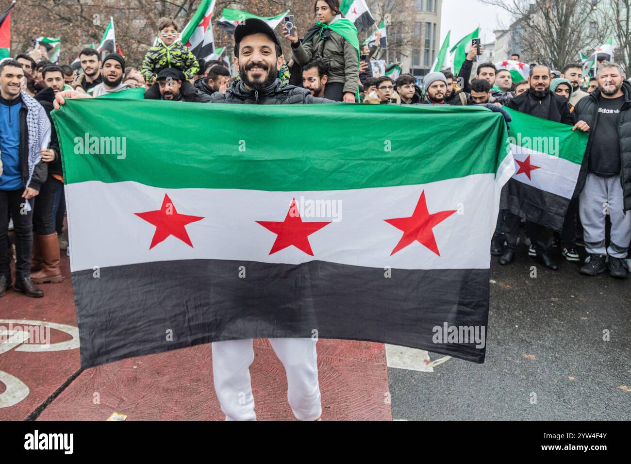 Berlin Germany 08th Dec 2024 A young man holds up a Free Syrian
