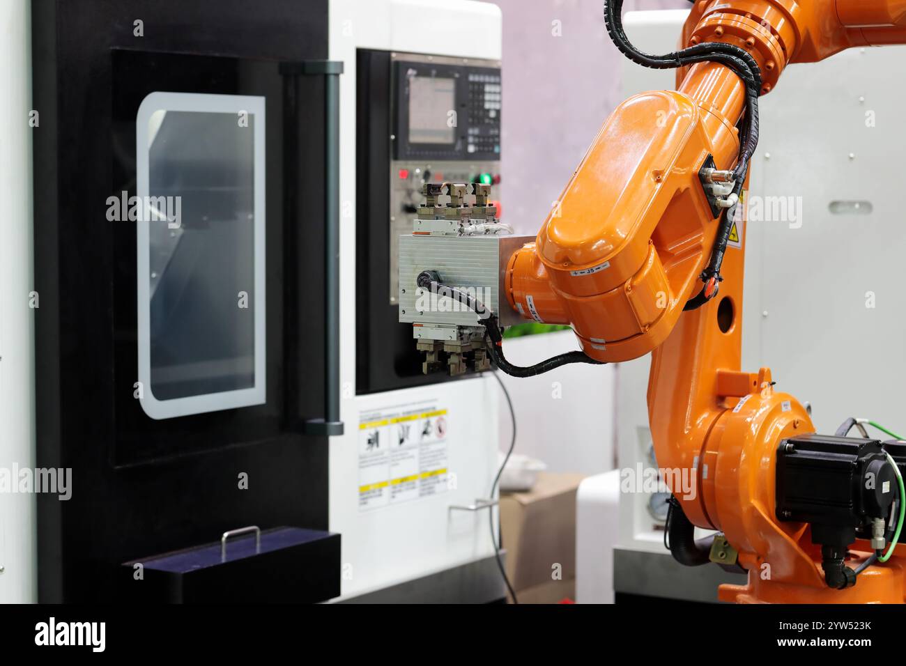 Collaborative robot and CNC machining center. Automated robotic workcell. Selective focus. Stock Photo