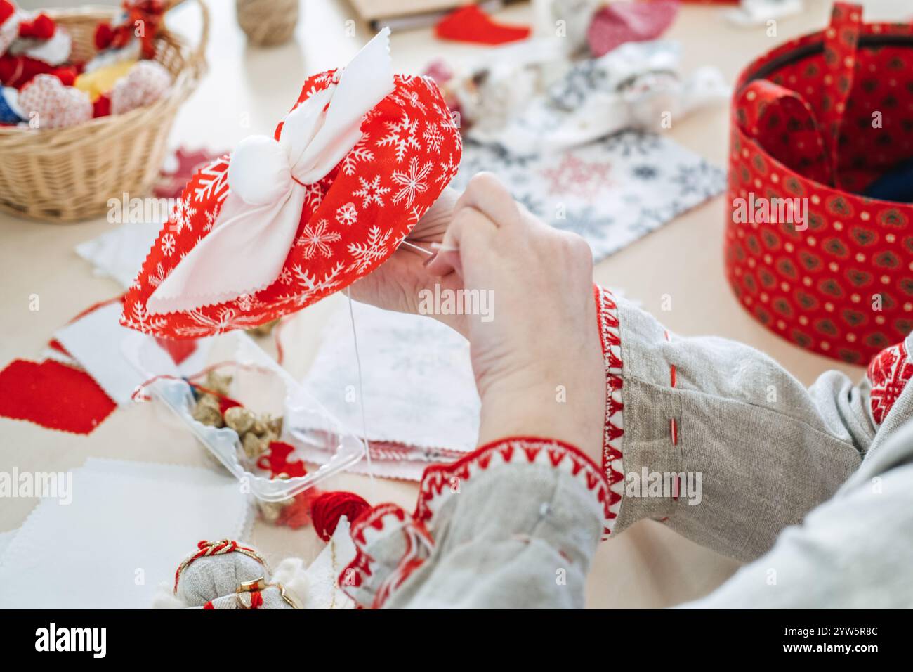 Handmaking Handmaking holiday decor with red and white fabric. Showcasing festive ...