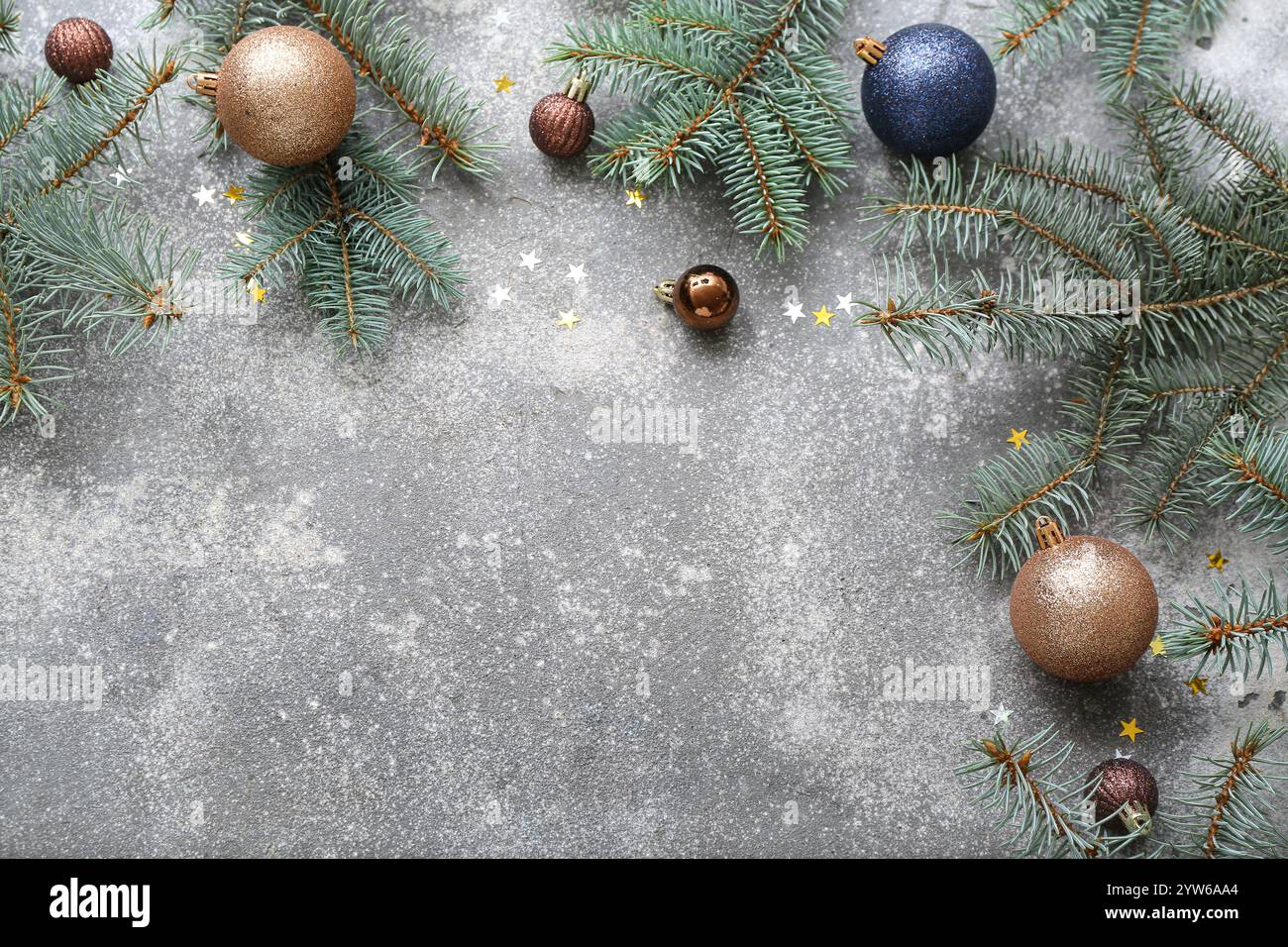 Christmas tree branches with balls and confetti on grey background ...