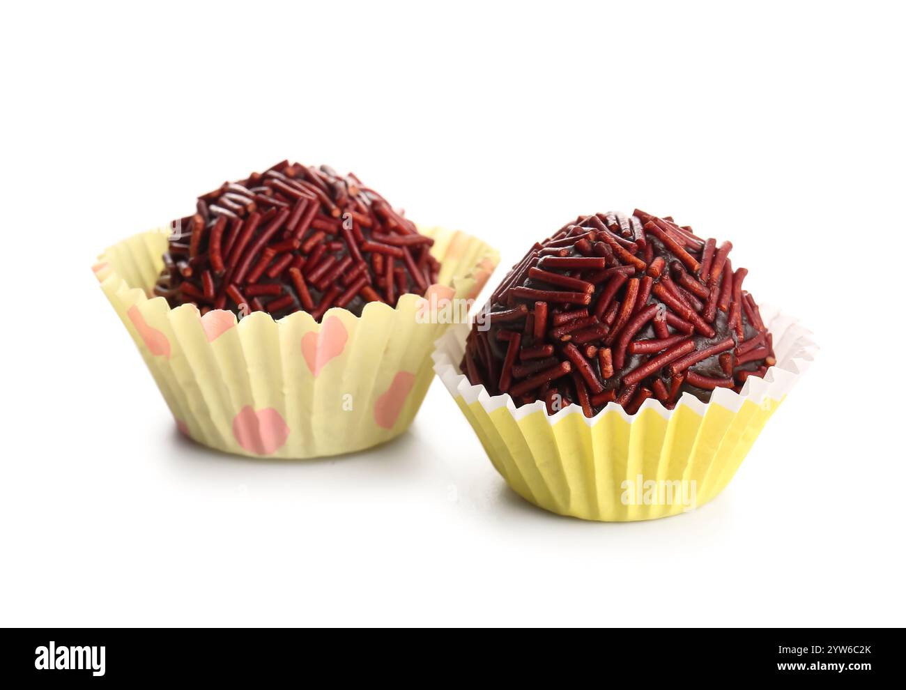 Delicious chocolate truffles in yellow paper cups on white background ...