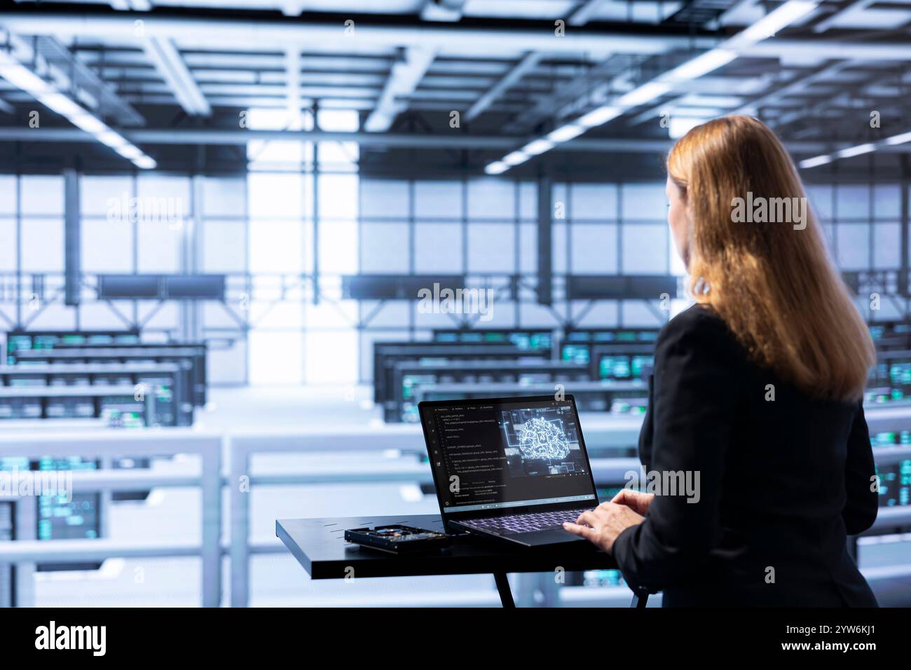 IT expert in data center updating AI systems, writing intricate binary code scripts on laptop. Certified admin using programming to upgrade artificial intelligence simulation model Stock Photo
