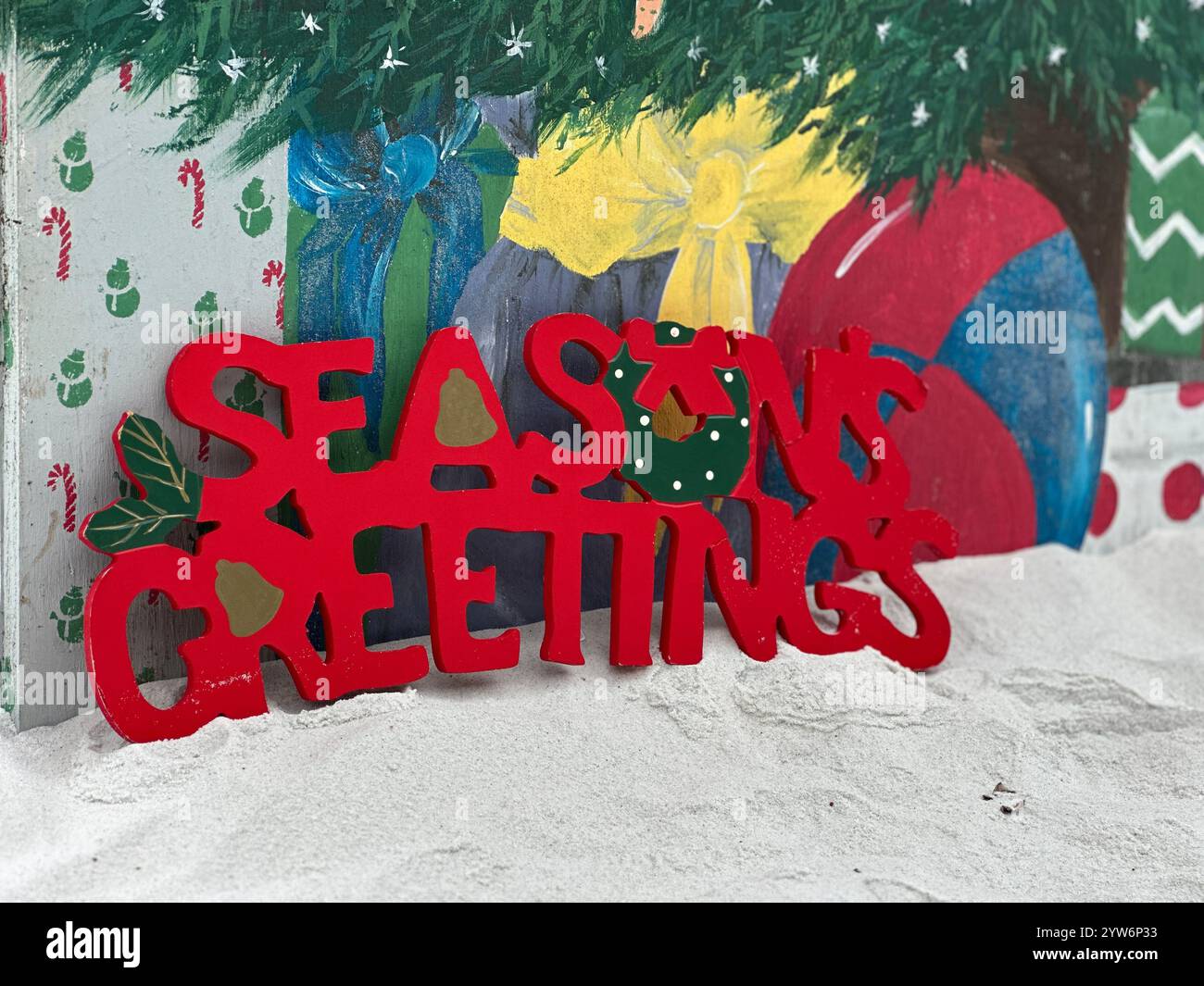 Christmas concept with greetings on white beach sand - Smartphone Captured Stock Image