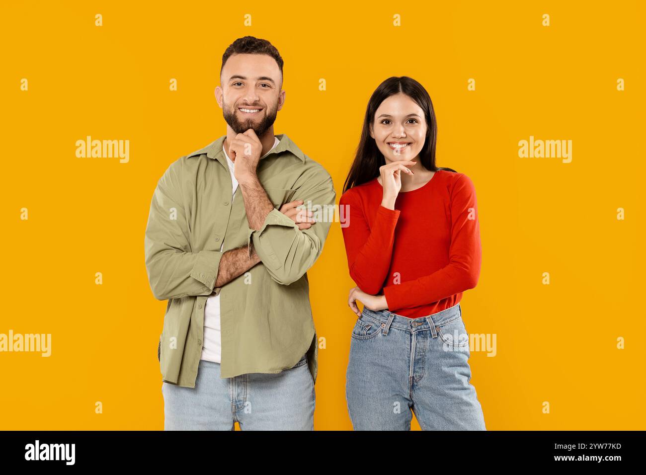 Happy couple posing playfully against a bright yellow background Stock ...
