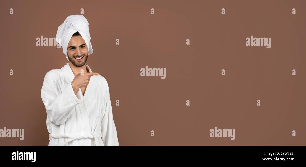 Young man in a bathrobe showing excitement in an indoor setting Stock Photo