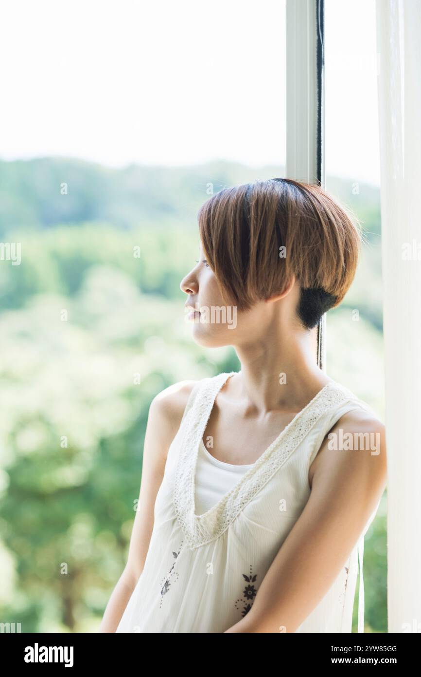 Woman in her 20s looking outside Stock Photo - Alamy