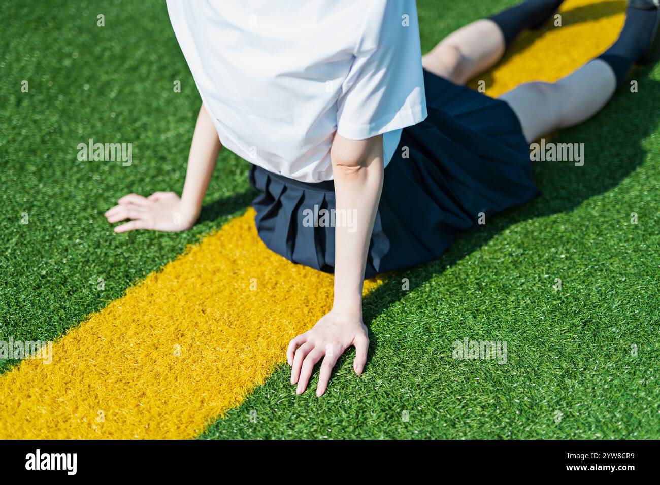 Female student sitting on lawn Stock Photo - Alamy
