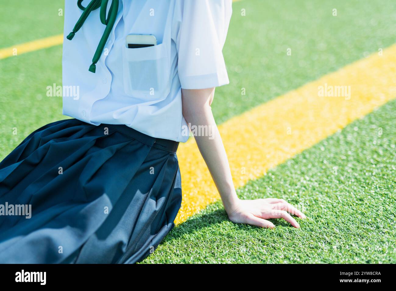 Female student sitting on lawn Stock Photo - Alamy