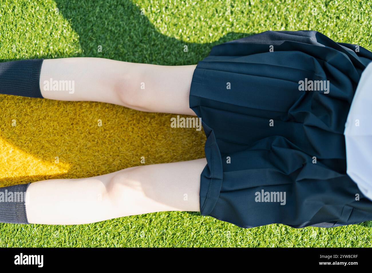 Female student sitting on lawn Stock Photo - Alamy