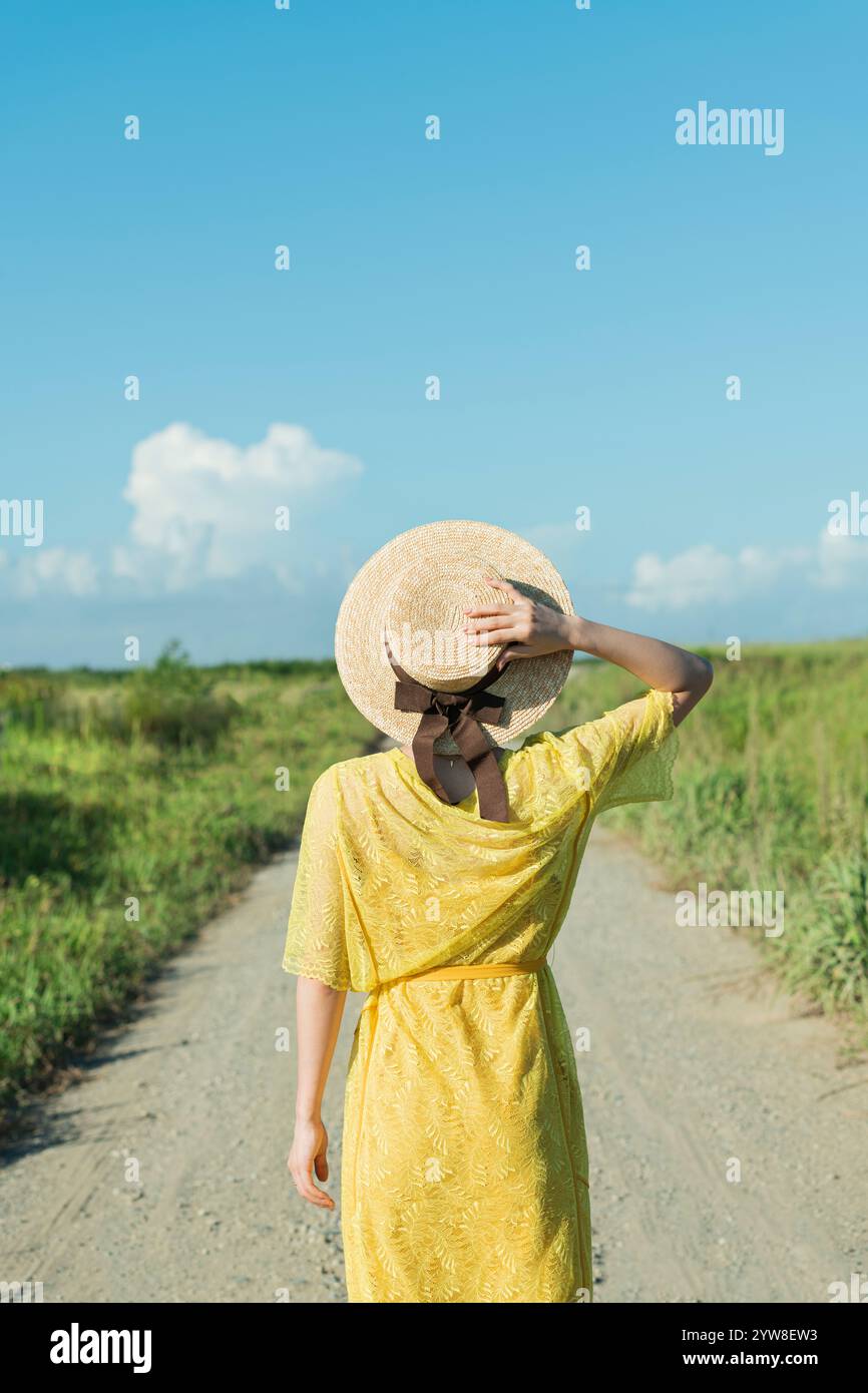 Woman walking on country road Stock Photo - Alamy