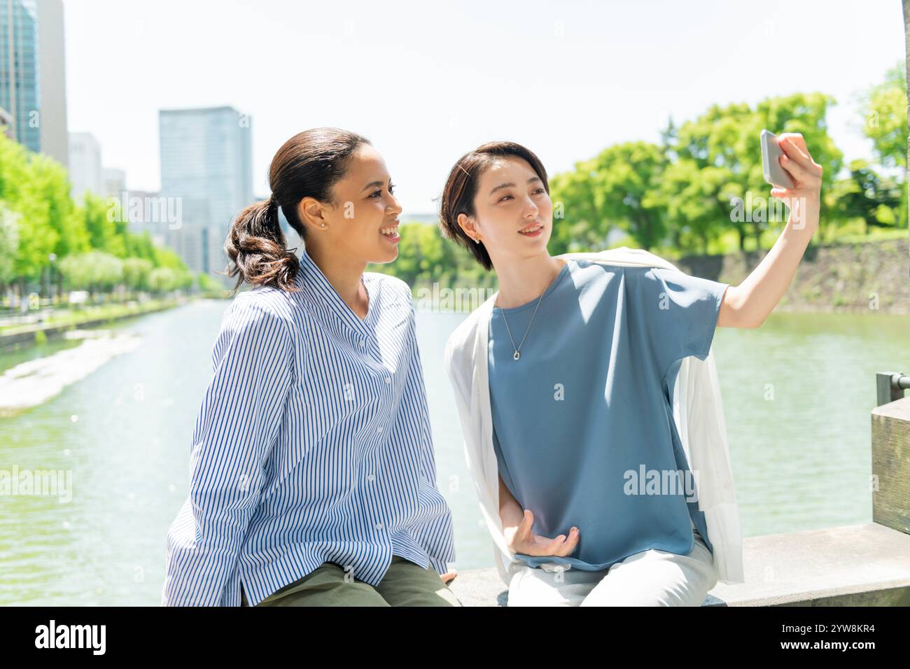 Two women taking selfies in the street Stock Photo - Alamy