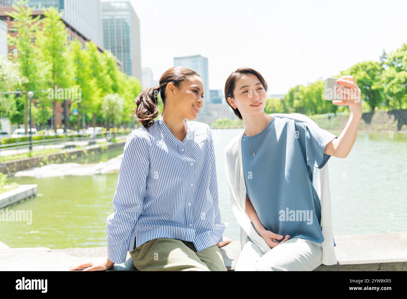 Two women taking selfies in the street Stock Photo - Alamy