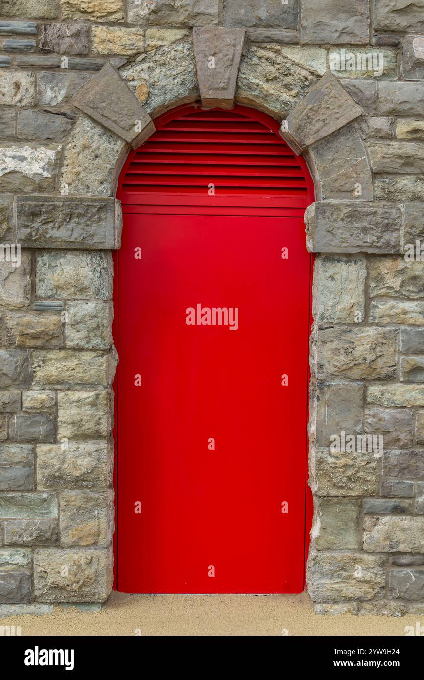 Red door in an old, brick wall Stock Photo