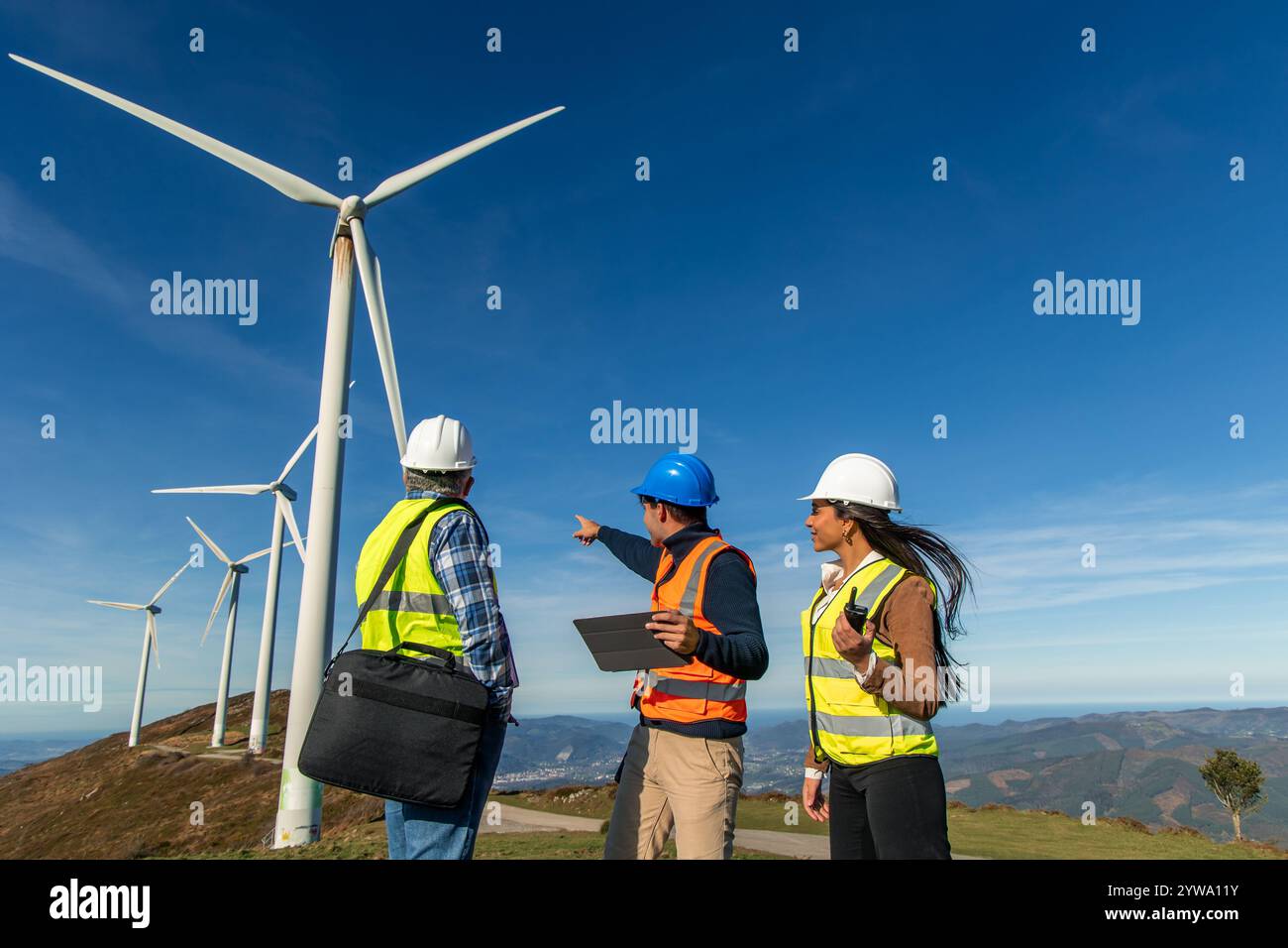 Three Multiethnic Engineers Wearing Safety Vests And Helmets Are