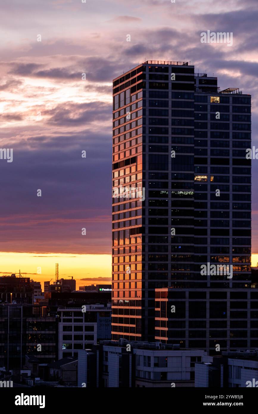 The skyscraper beautifully reflecting the vibrant colors of a sunset ...