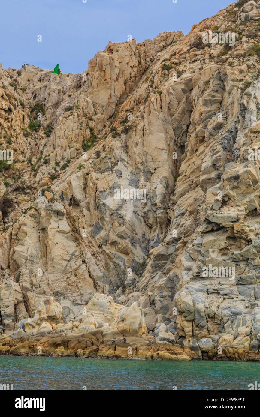 Pointy Rocks At Cliffs A rocky cliff with a green statue on top. The statue is surrounded by ...