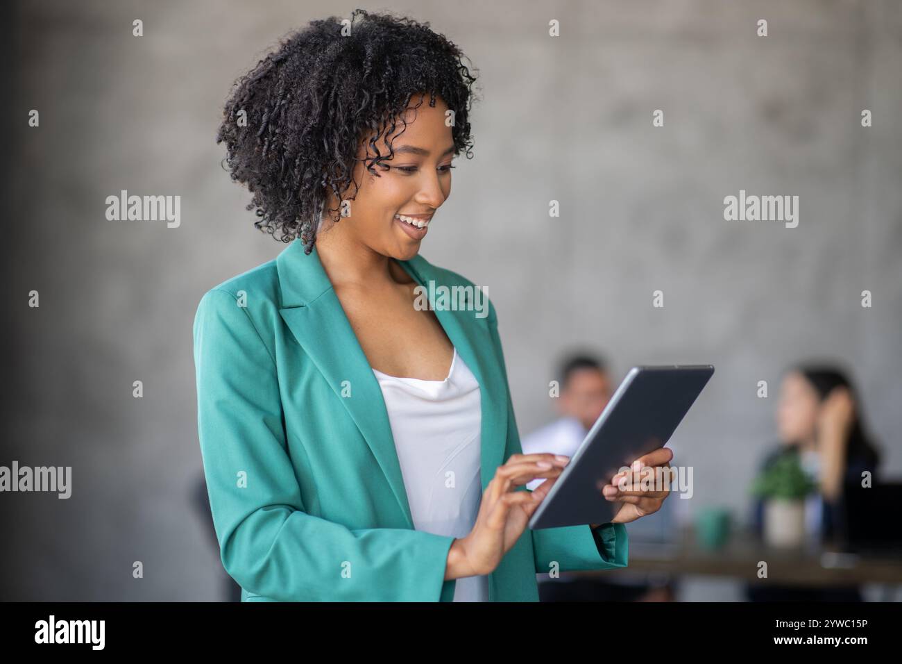 Diverse team collaborates in modern office space using digital devices Stock Photo