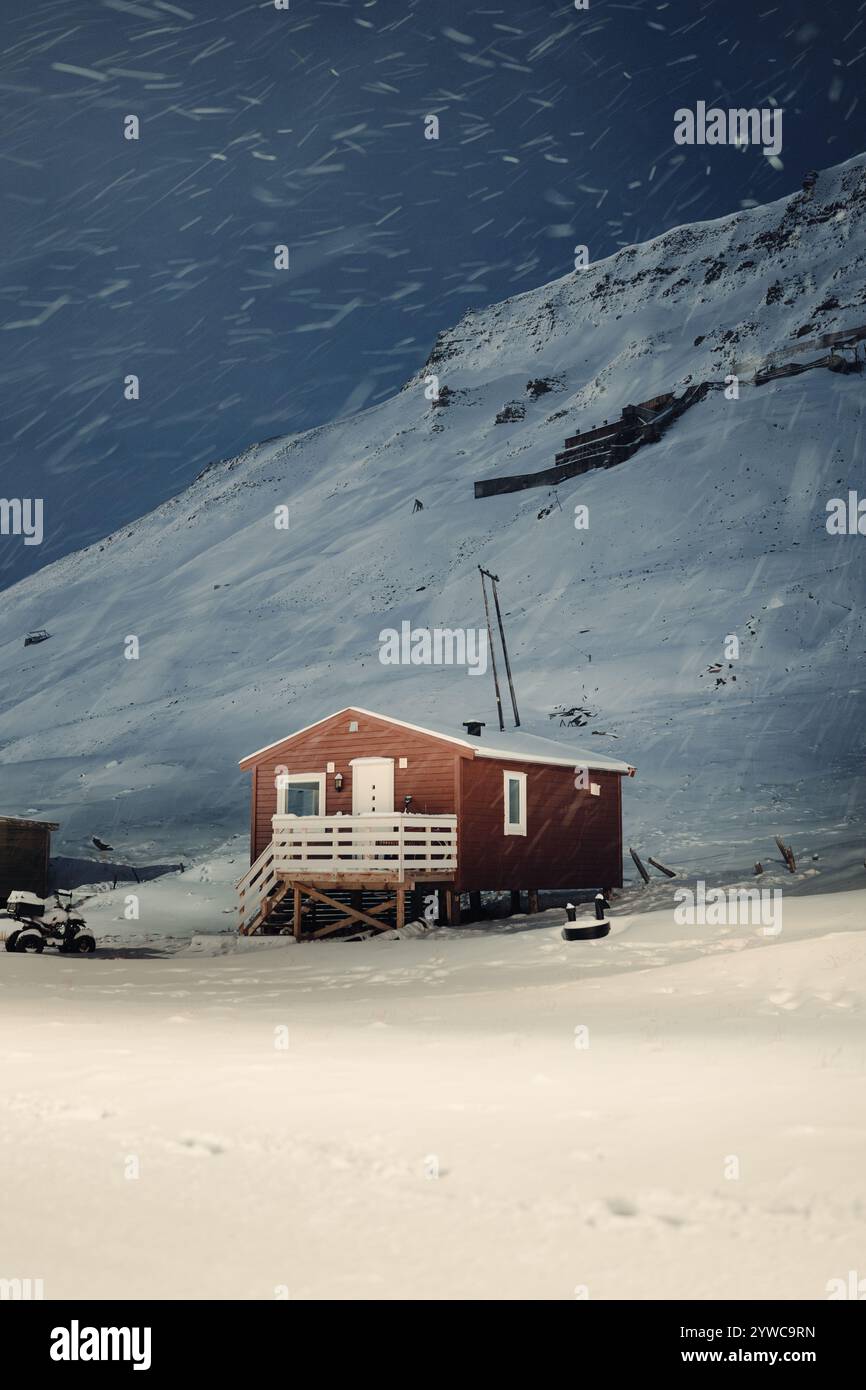 Snowing on small wooden cabin under mountain in Longyearbyen, Svalbard ...