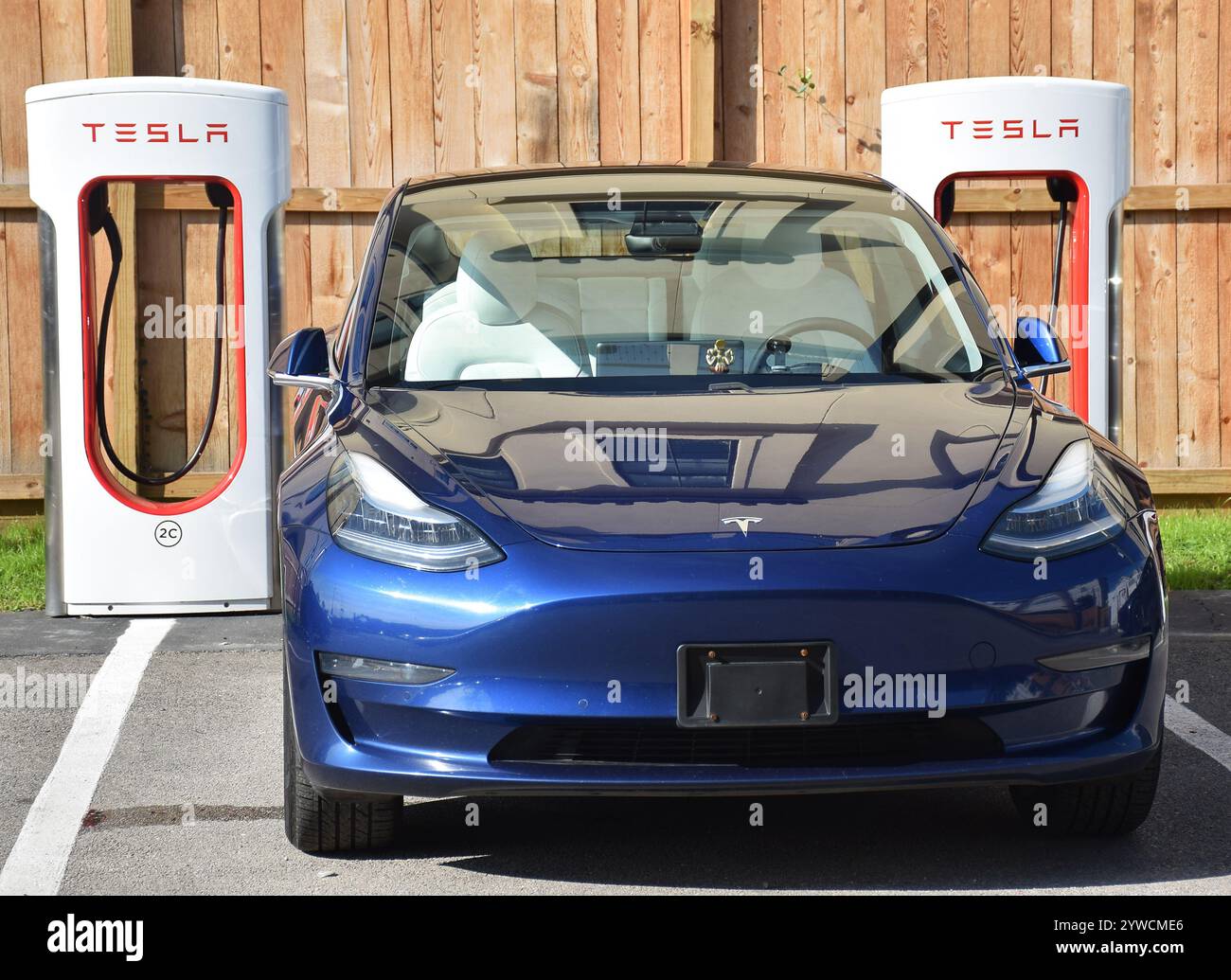 A Tesla car stationed at a tesla charging station for charging Stock ...