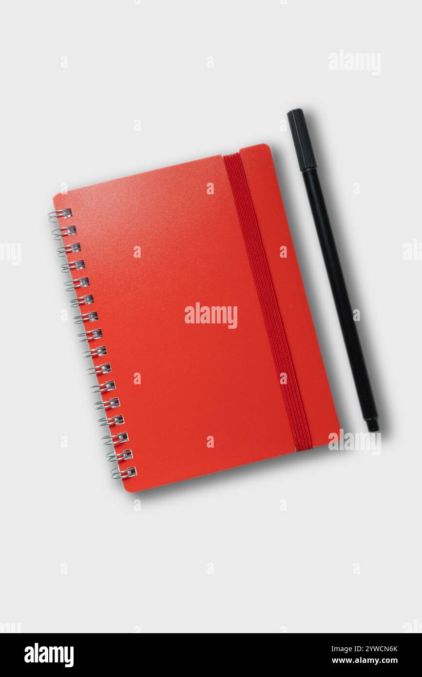 red notebook with pencil. school notebook on cyan background, spiral notepad on table Stock Photo