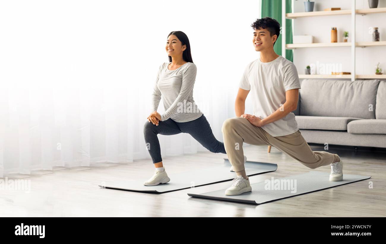 Motivated asian couple exercising at home, copy space Stock Photo