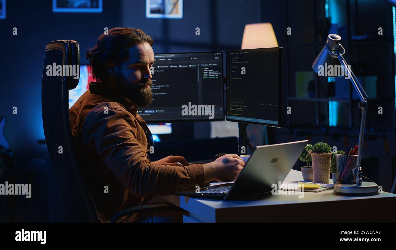Software programmer putting headphones on while developing code, making time pass faster during remote job shift. IT professional doing multitasking in apartment office while listening music, camera A Stock Photo
