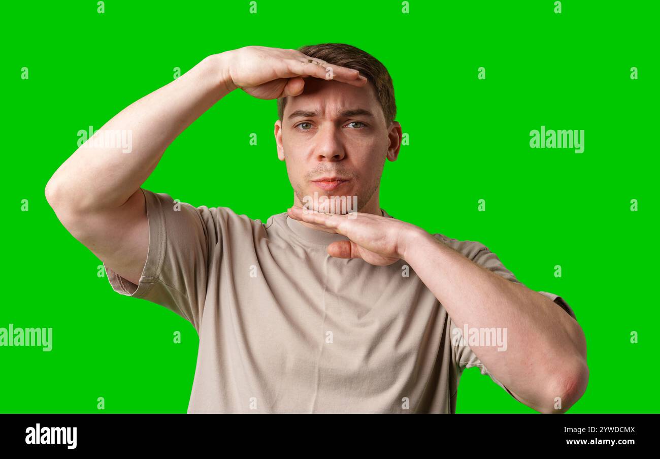 A man with short hair poses against a vibrant green background Stock ...