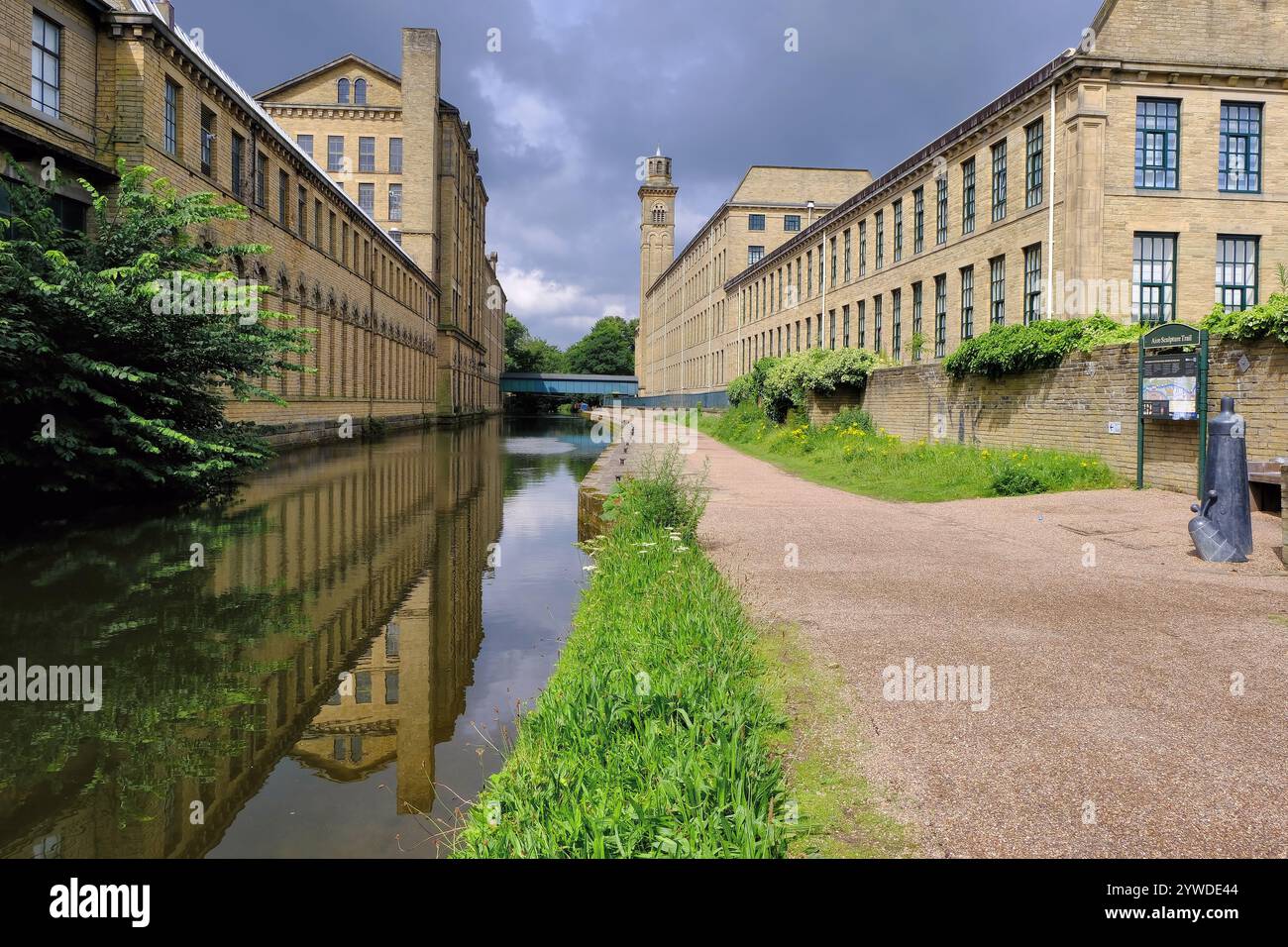 Saltaire: Old salts mill with mirror reflections in Leeds Liverpool Canal at Victorian model village of Saltaire, Shipley, Yorkshire, England, UK Stock Photo