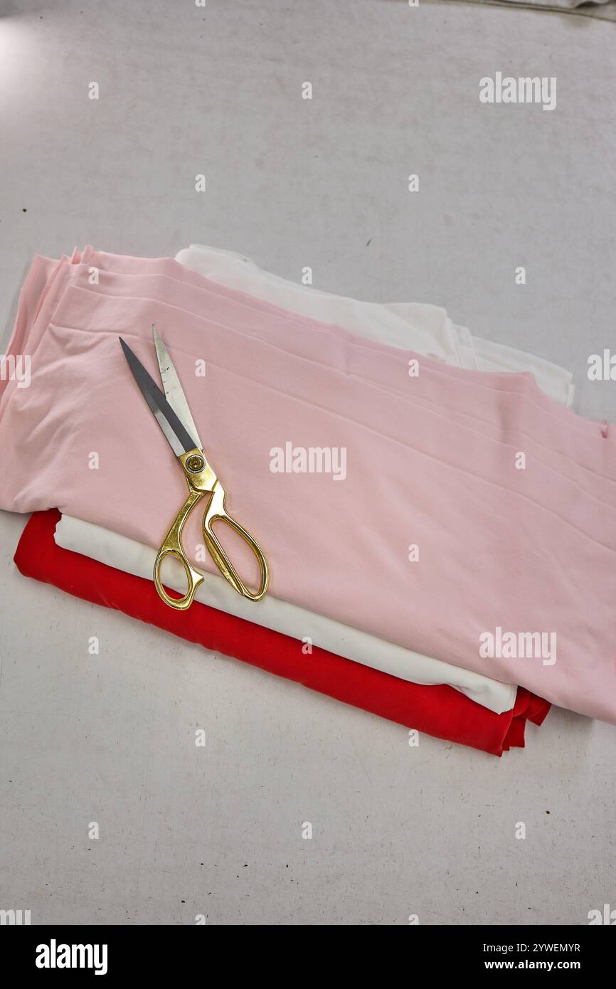 A stack of colorful fabric with a pair of scissors, ready for a sewing ...