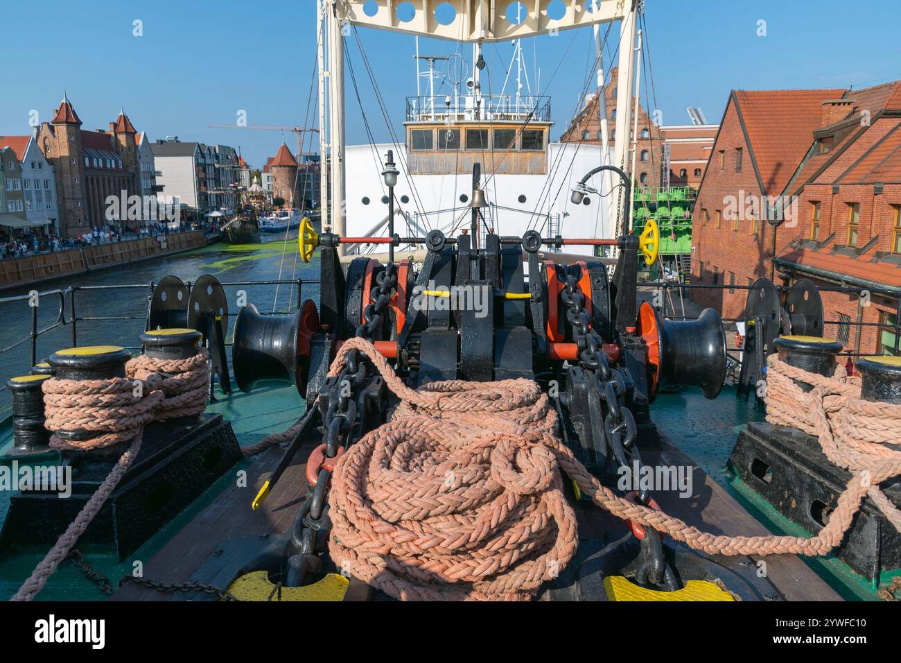 Ship's deck showing ropes, chains, winches, and vibrant harbor scenery ...