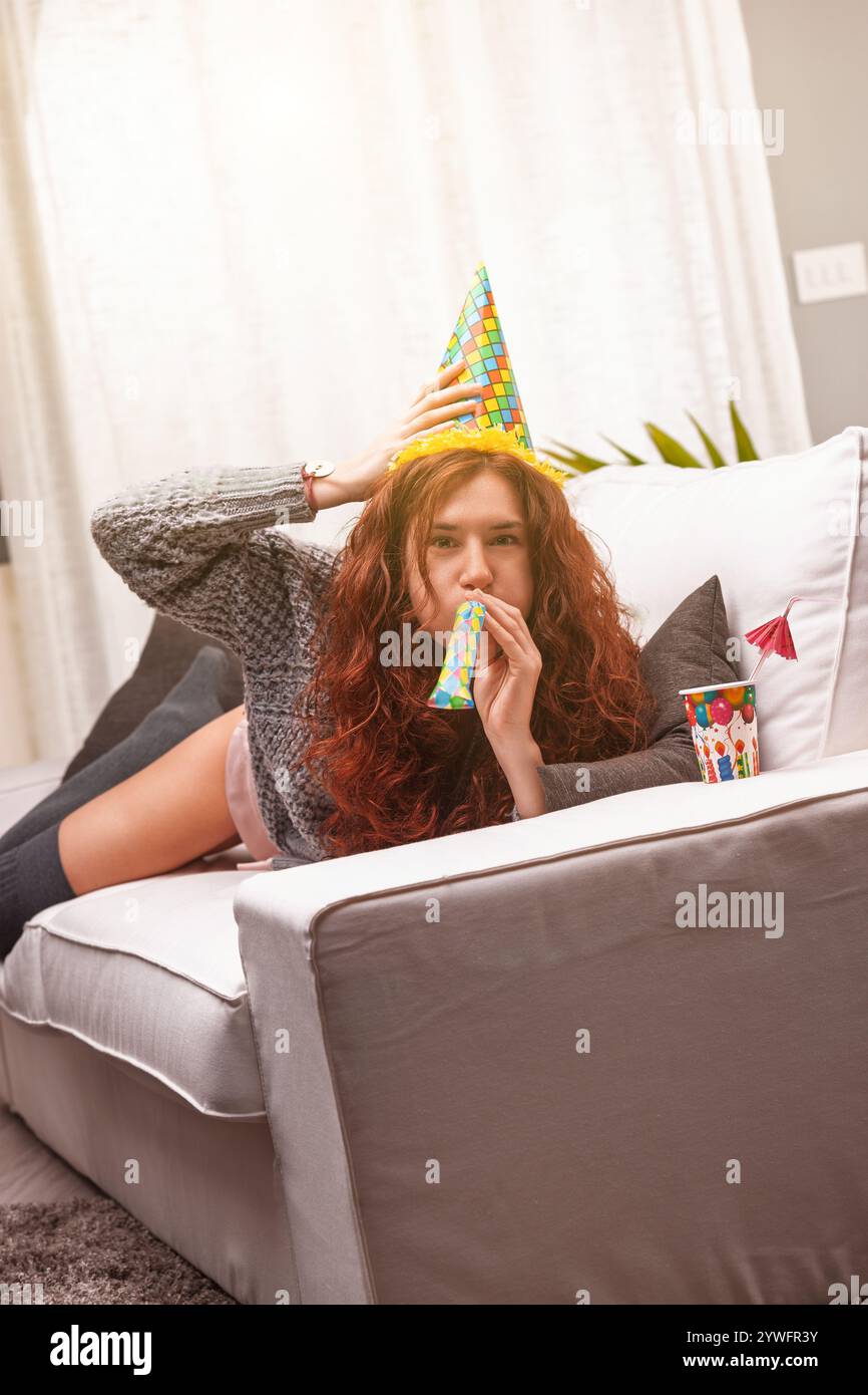 Young woman blowing party horn hi-res stock photography and images - Alamy