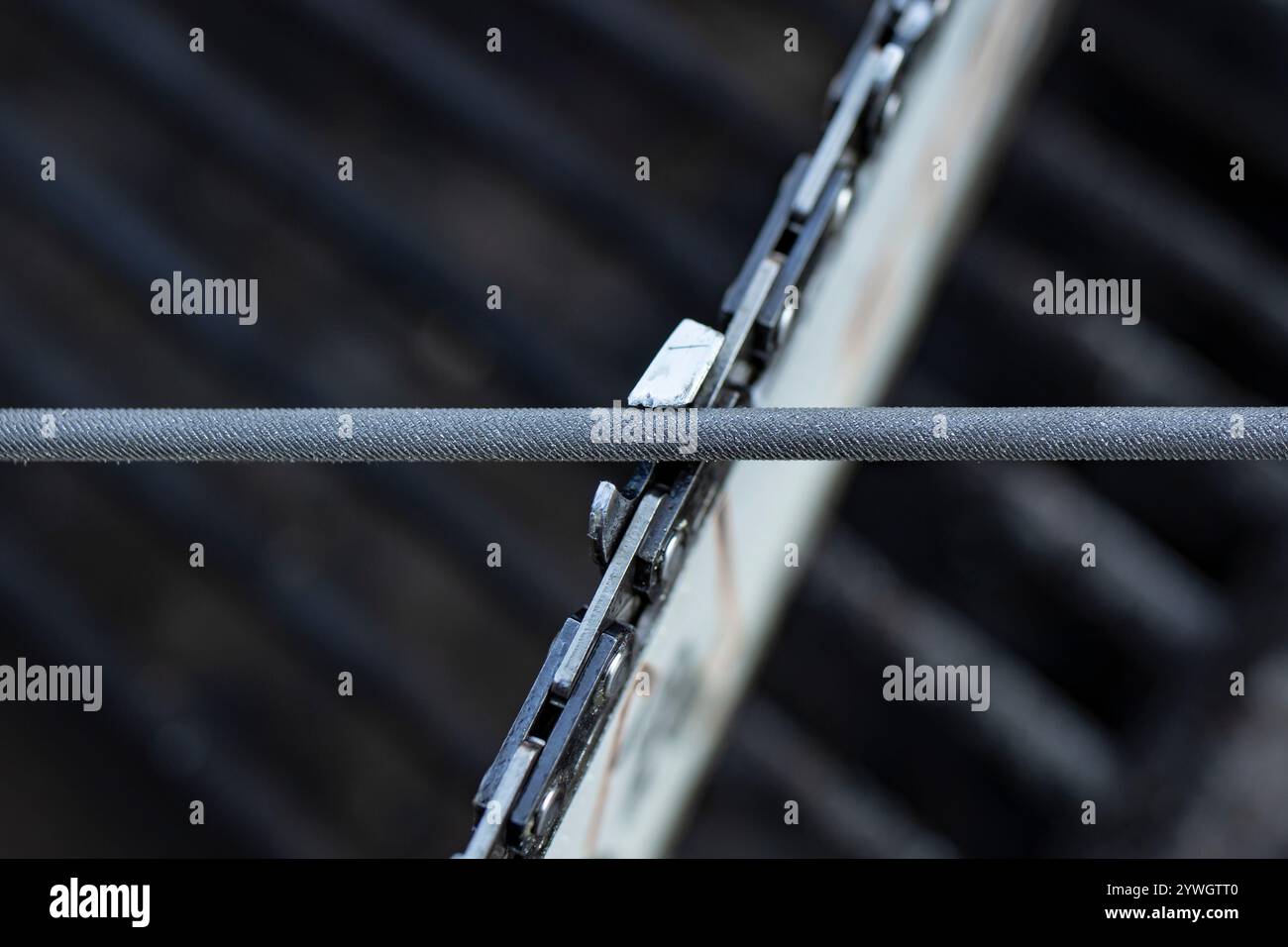 Chainsaw chain sharpening with a special round file, soft focus Stock Photo