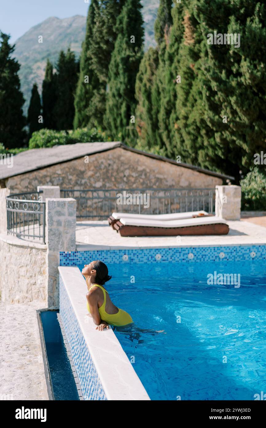 Woman sunbathing by a swimming pool hi-res stock photography and images ...