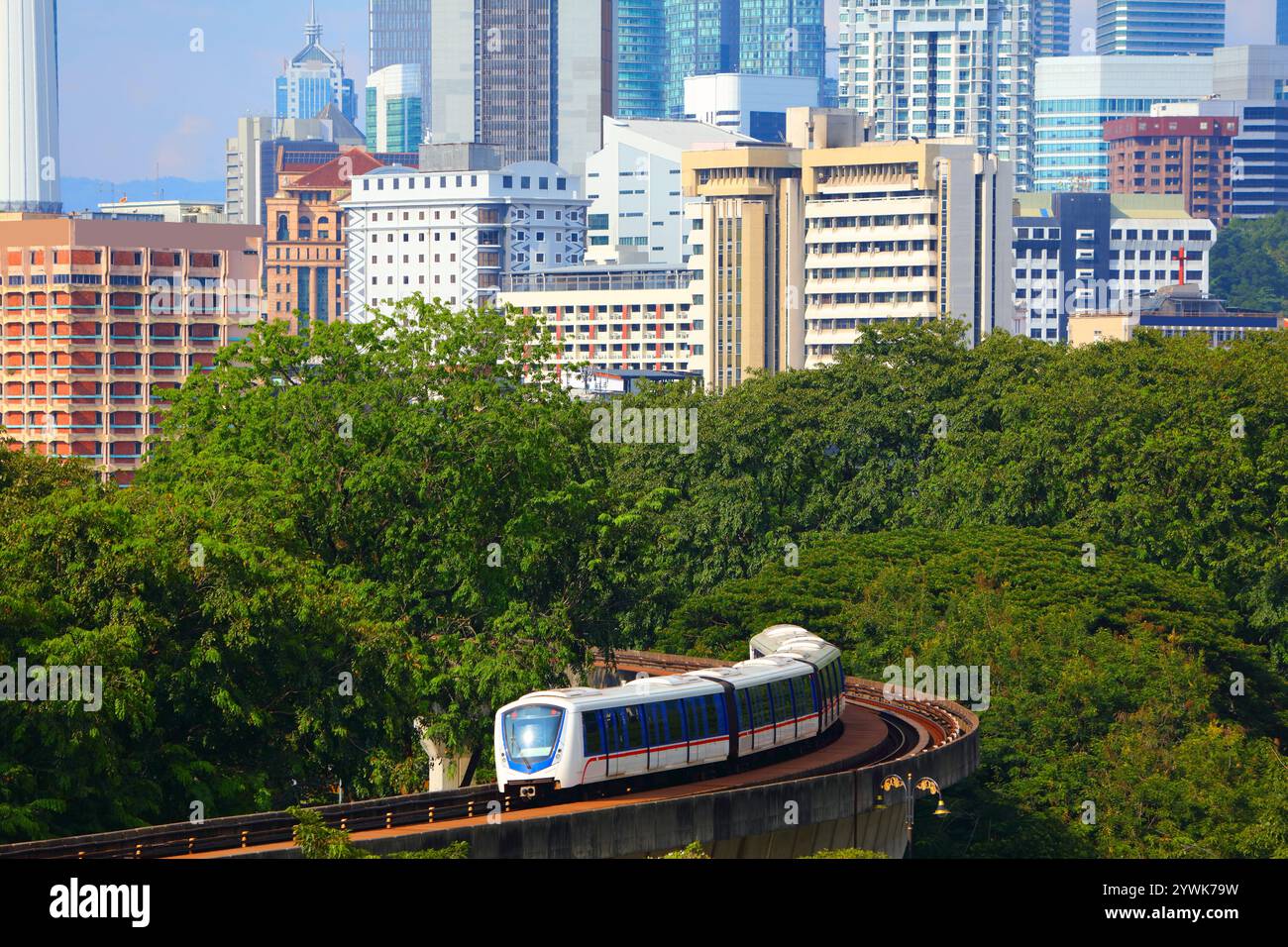 Kuala Lumpur city skyline with LRT public transportation train on elevated railway tracks. Kuala Lumpur, Malaysia. Stock Photo