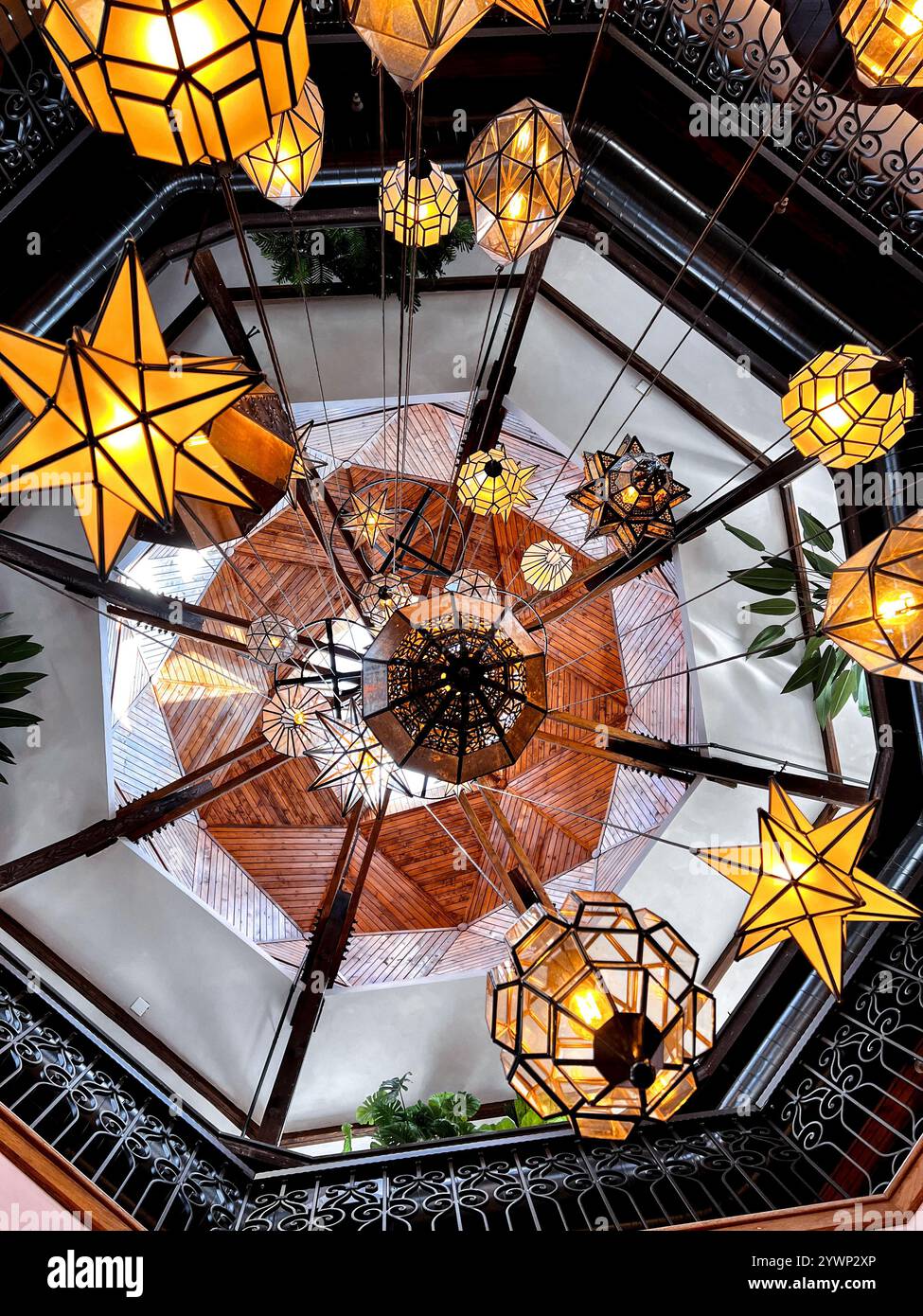This image of a Spanish inspired chandelier captures the bold colors of orange that elegantly contrast against the deep iron. - Smartphone Captured Stock Image