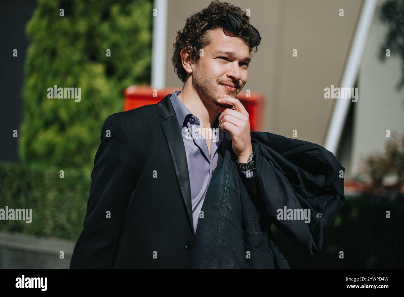 Confident businessman thinking outdoors in a formal suit Stock Photo