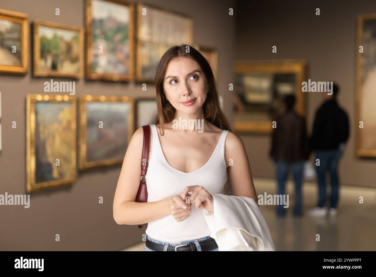 Woman at an exhibition of paintings in a gallery Stock Photo - Alamy