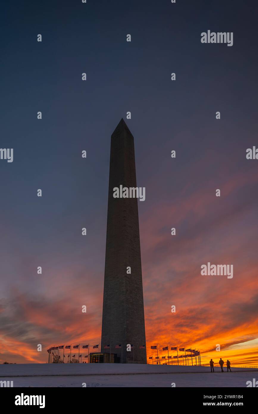 The Washington Monument at Sunset. A vivid Orange and Pink Sky with U.S. Flags. Stock Photo