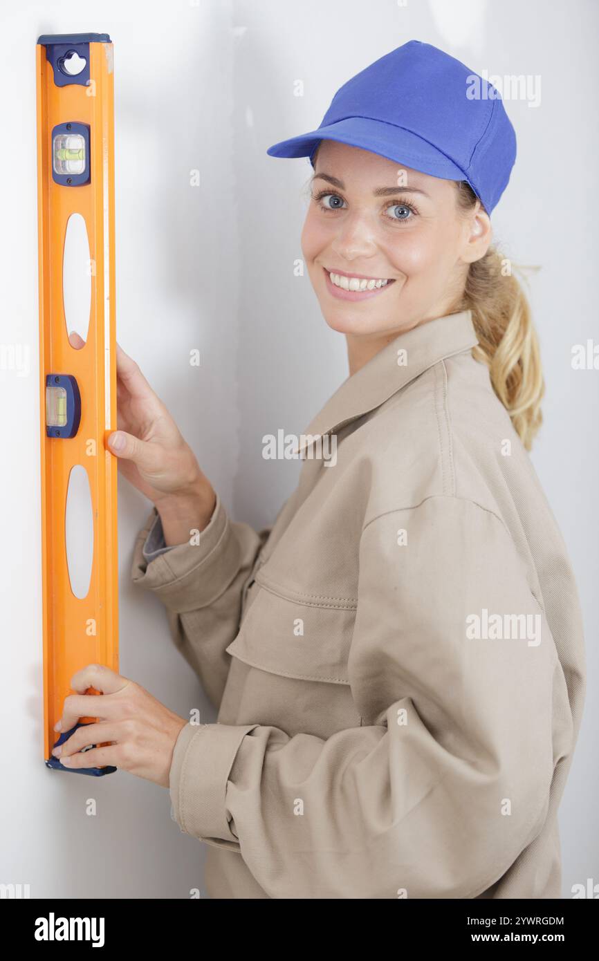 female builder using a spirit level Stock Photo
