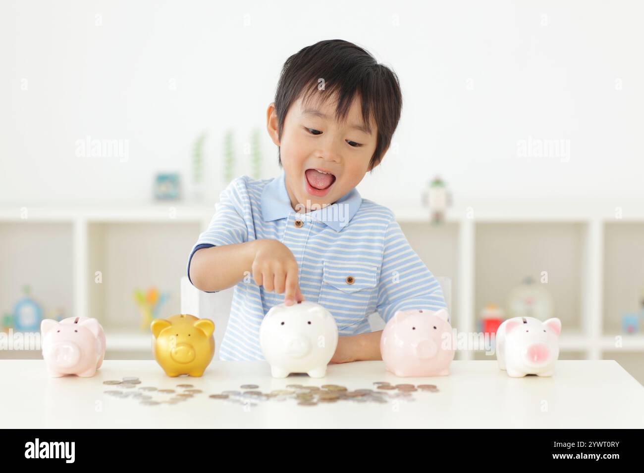 Boy putting money into piggy bank Stock Photo - Alamy