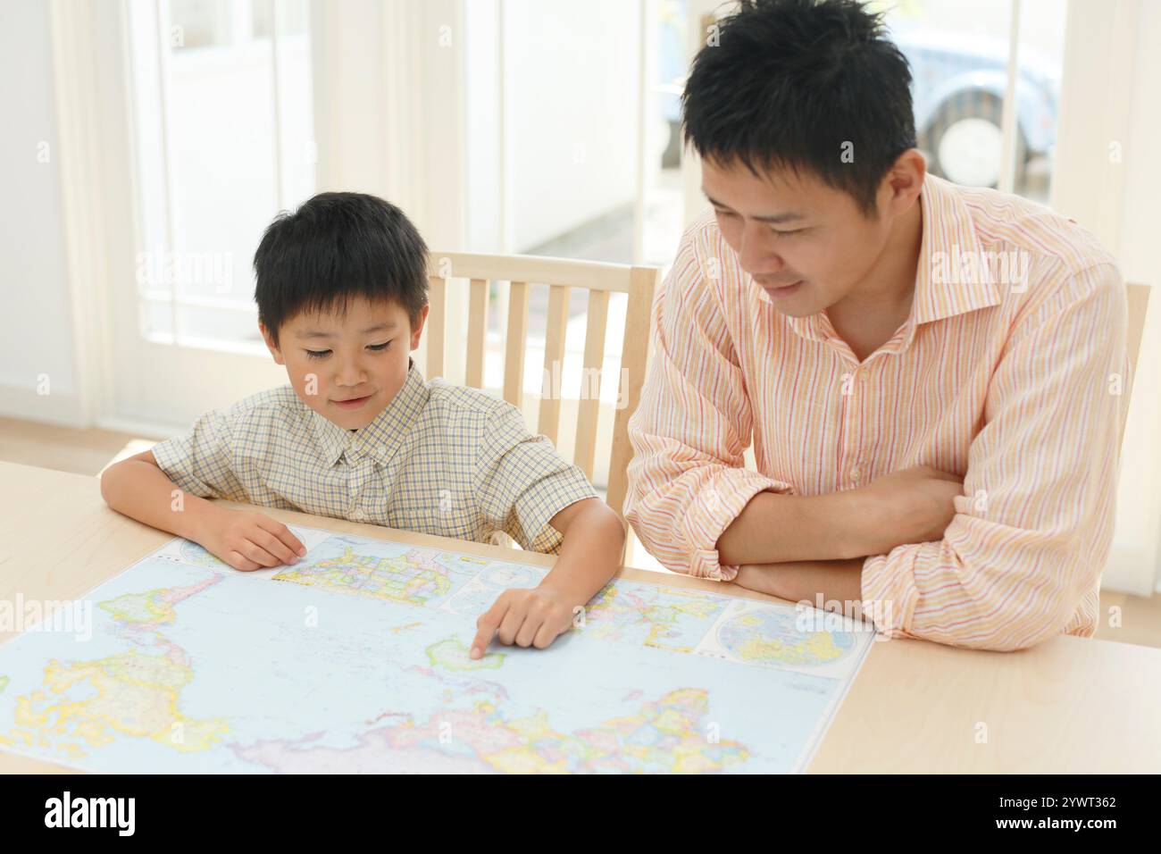 Father and child spreading map at table Stock Photo