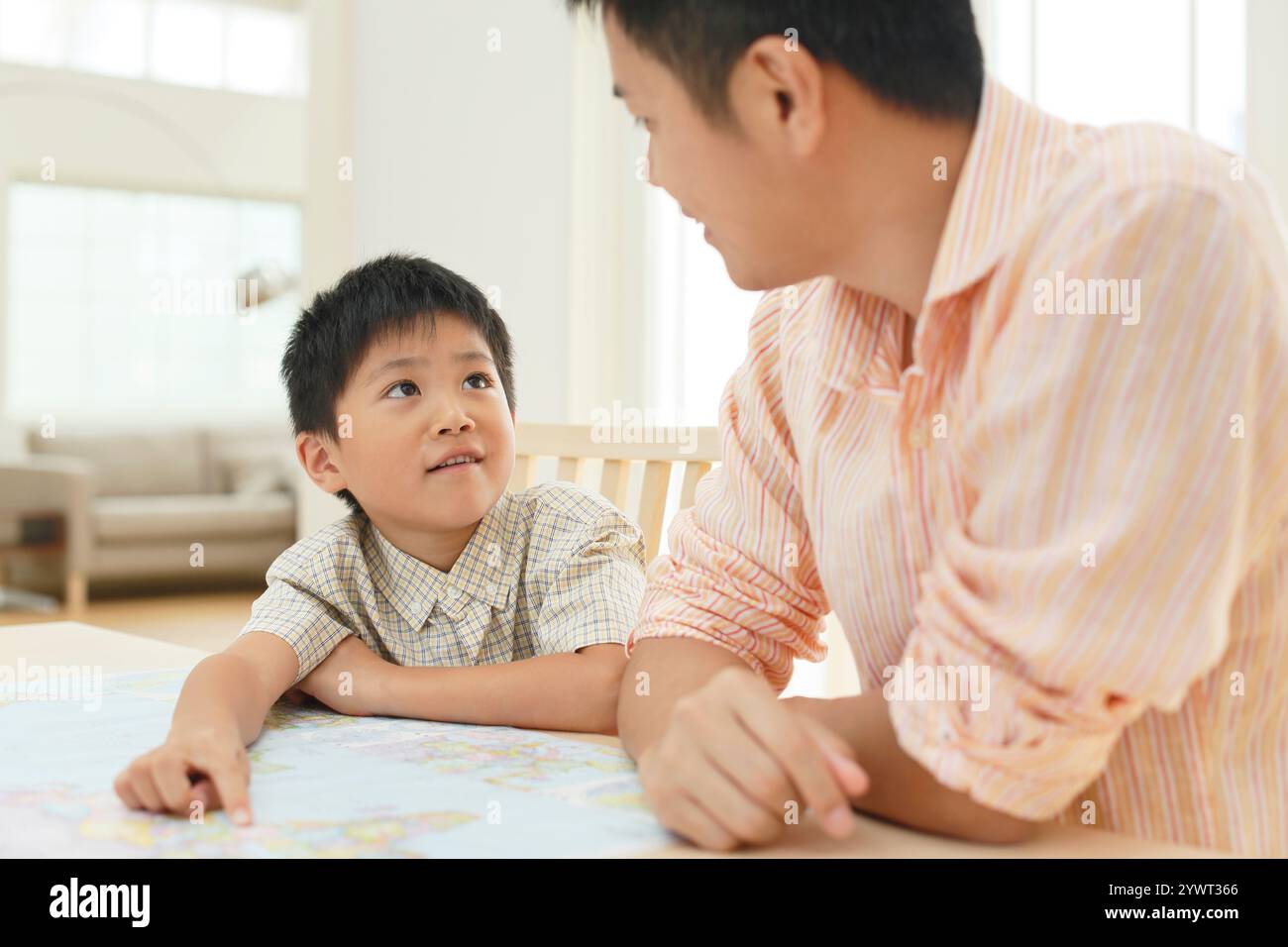 Father and child spreading map at table Stock Photo