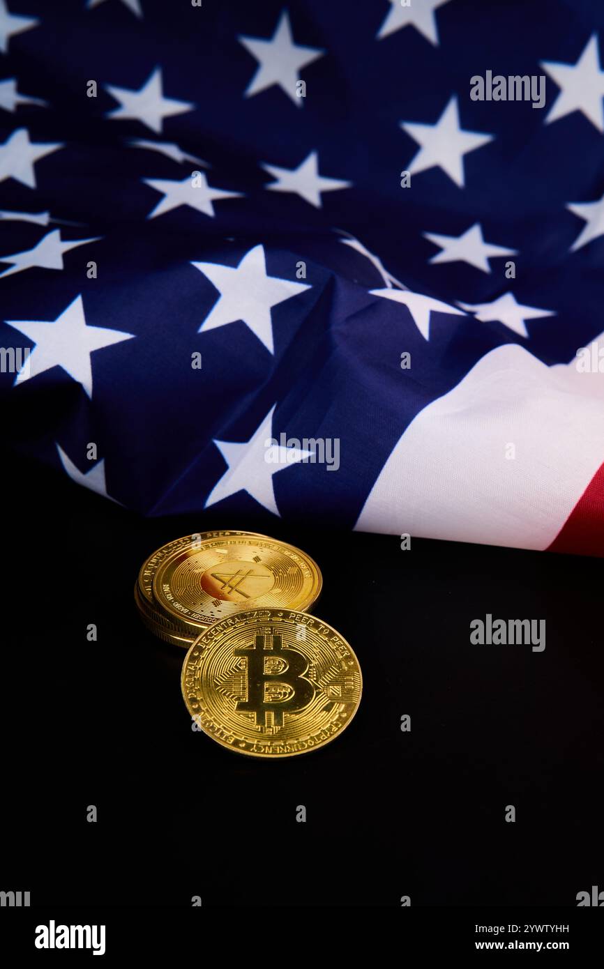 Two bitcoins are placed in front of the American flag, symbolizing their relevance in the digital economy and the United States technological advancem Stock Photo