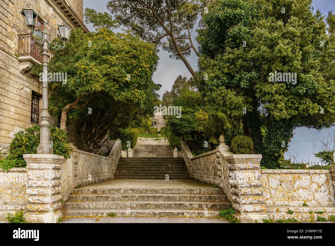 Beautiful stone stairs integrated into the building and the surrounding green garden. Stock Photo