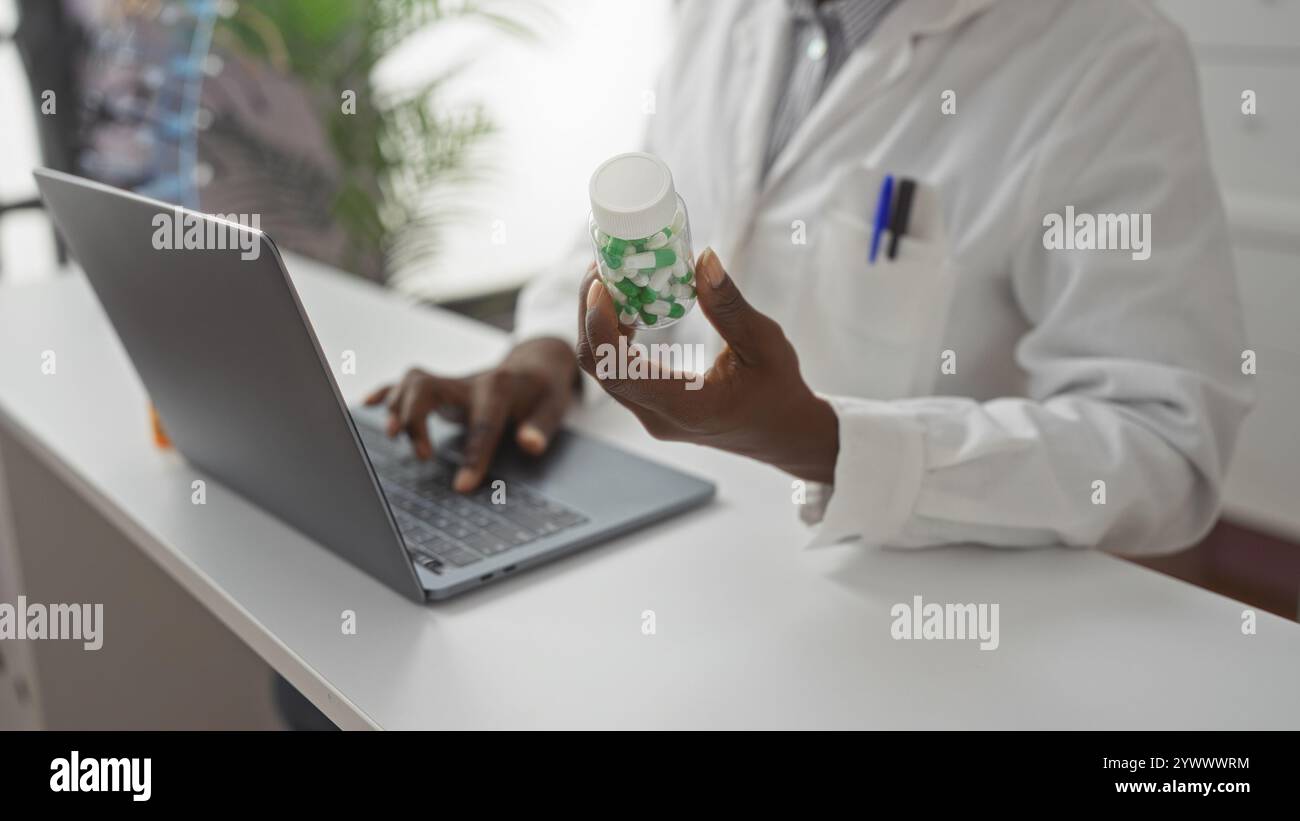 Pharmacist Using A Computer Pharmacist working on laptop holding pill bottle in pharmacy Stock ...