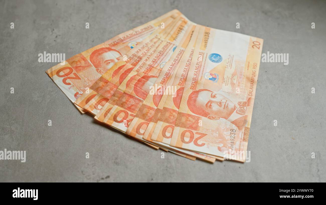 Philippine peso banknotes displayed on a concrete surface, showcasing ...