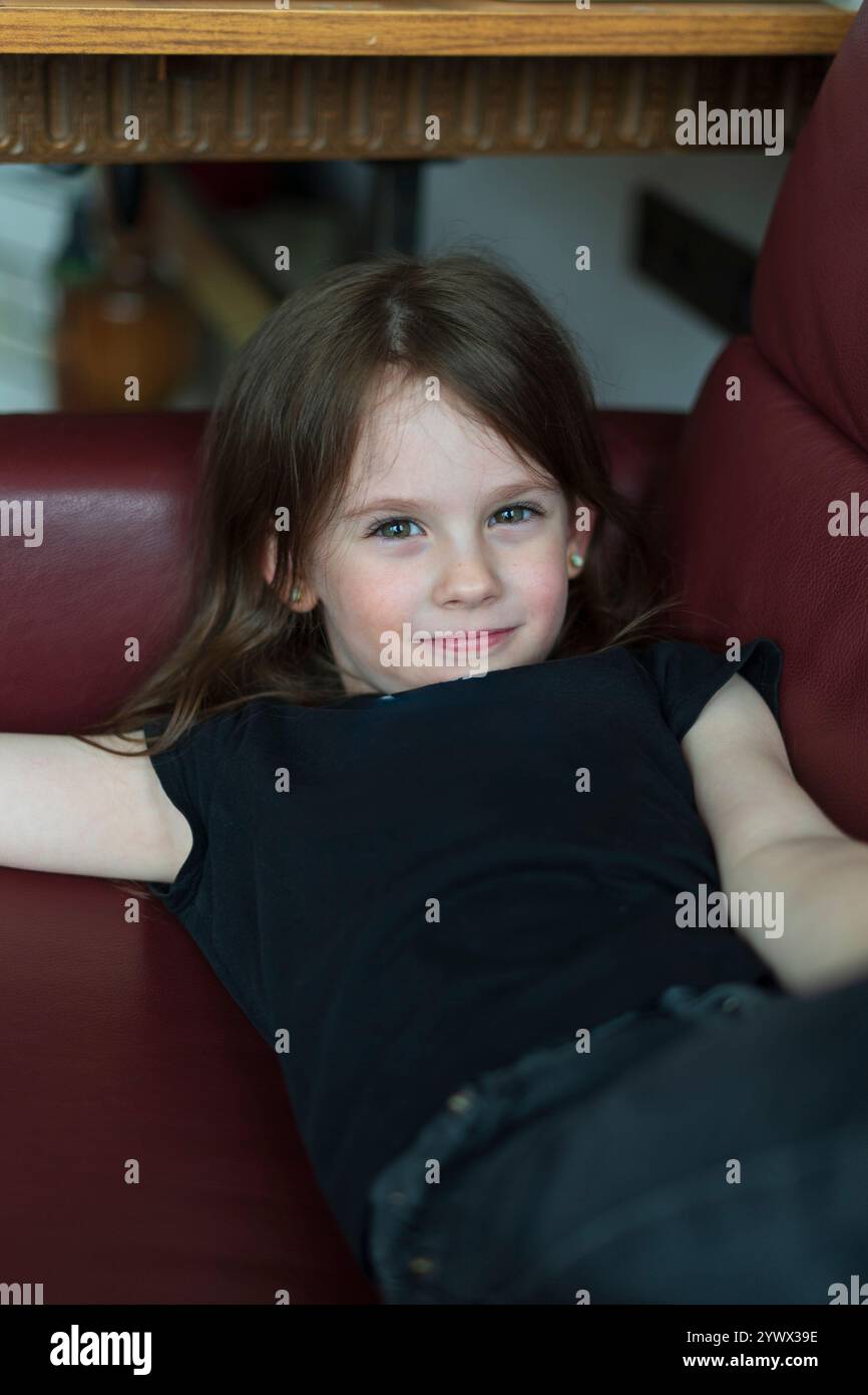 Little smiling girl in a chair Stock Photo - Alamy